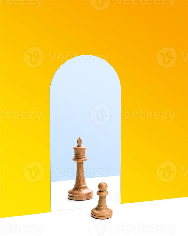 pedina degli scacchi davanti al riflesso della regina degli scacchi nello specchio foto