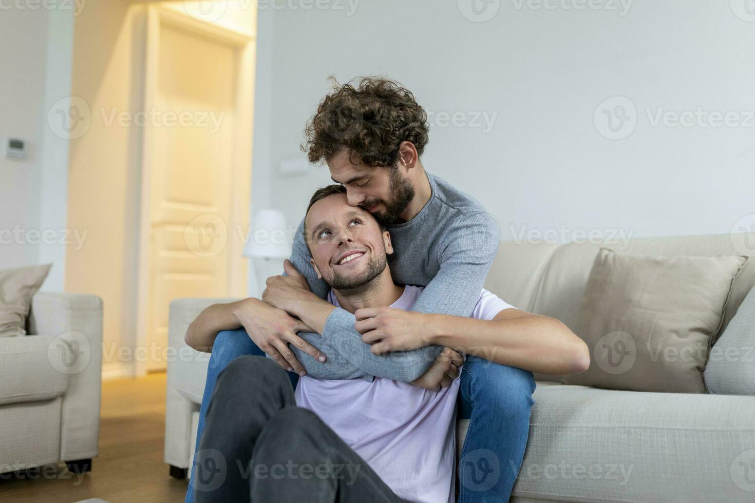 amorevole stesso sesso maschio gay coppia dire bugie su divano a casa e rilassante, coccole insieme foto