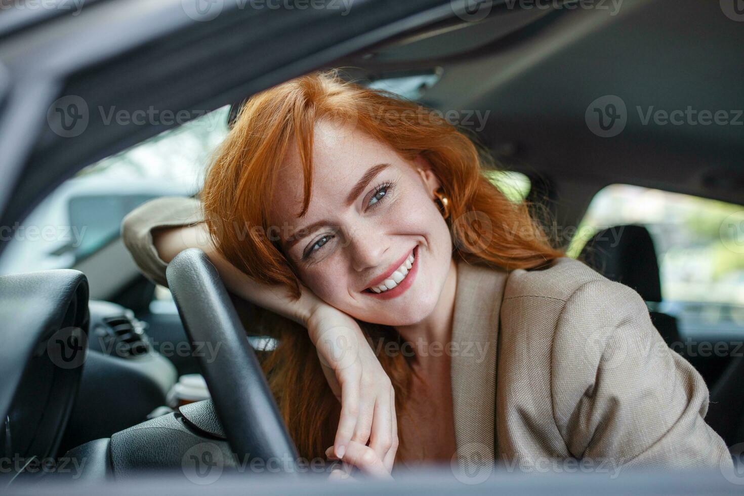 giovane donna Abbracciare una persona sua nuovo macchina. eccitato giovane donna e sua nuovo auto al chiuso. giovane e allegro donna godendo nuovo auto abbracciare timone ruota seduta dentro foto