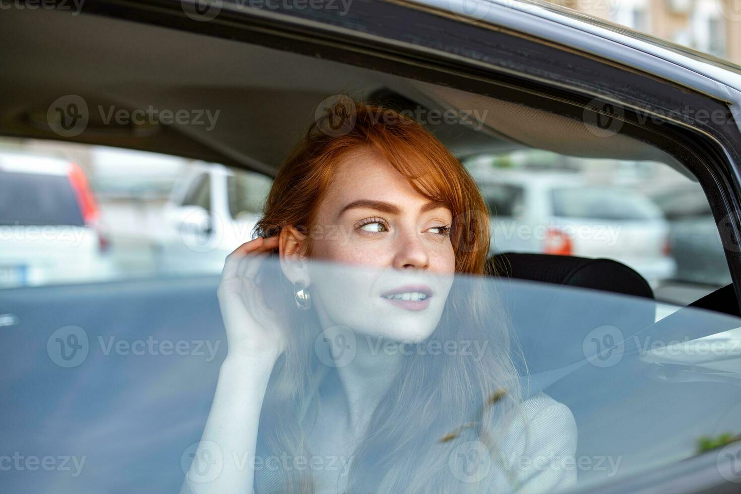 fiducioso e Bellissima. davanti Visualizza di attraente giovane rosso capelli donna nel casuale indossare guardare lontano mentre guida un' auto durante il giorno. bellissimo sorridente donna guida macchina, seduta nel automobile foto