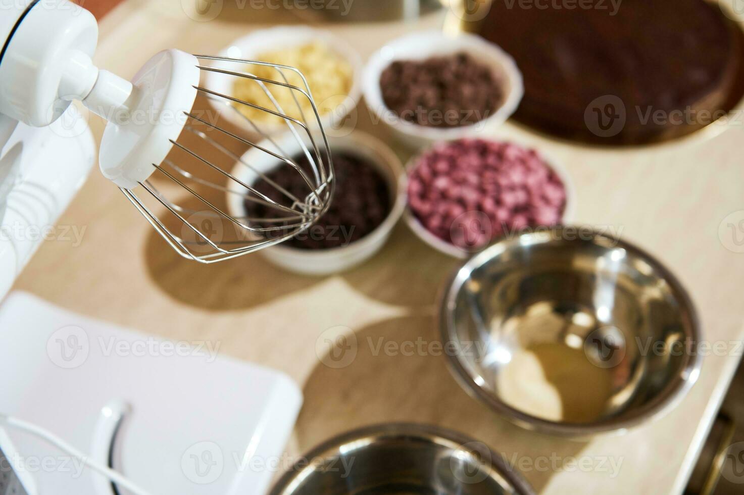 messa a fuoco su frusta di cibo processore su cucina contatore con sfocato biologico scuro, latte, bianca e rubino rosa cioccolato patatine fritte foto