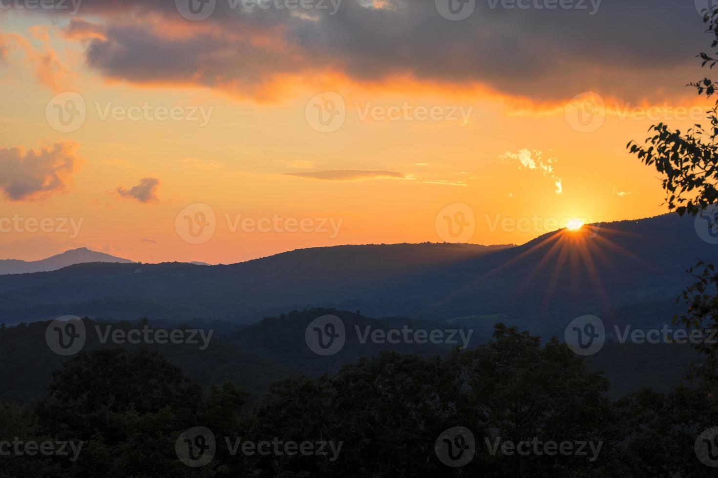 il sole scende sotto l'orizzonte sulla cresta blu foto