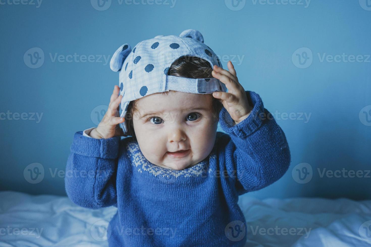 piccolo bambino che gioca con un berretto foto