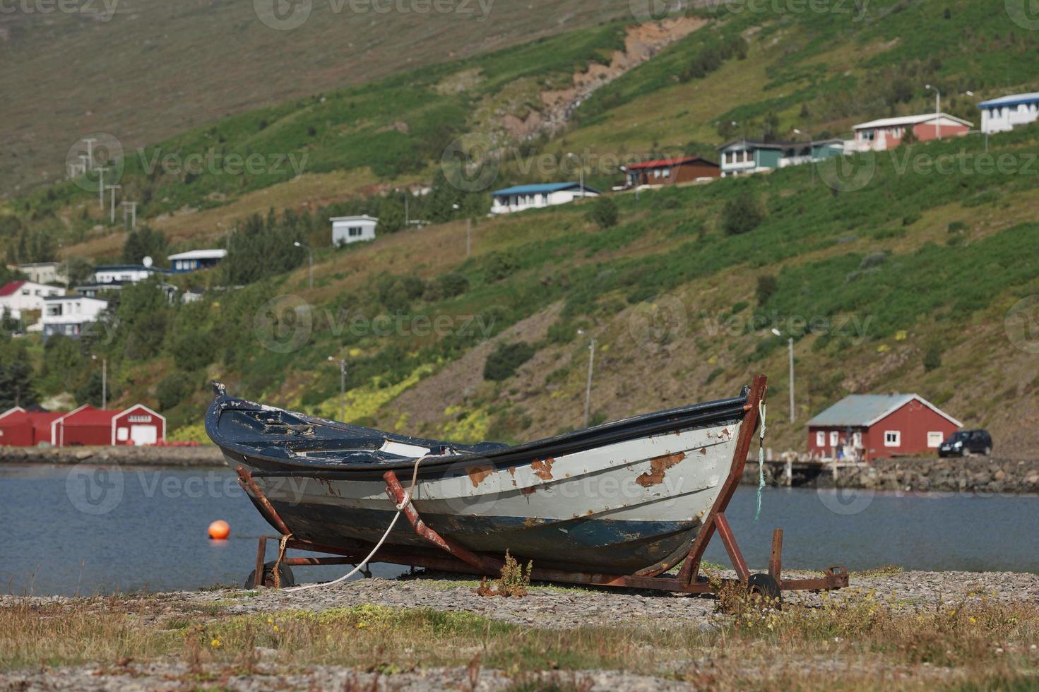 vecchia barca d'epoca con una piccola città di eskifjodur situata nell'Islanda orientale in background foto