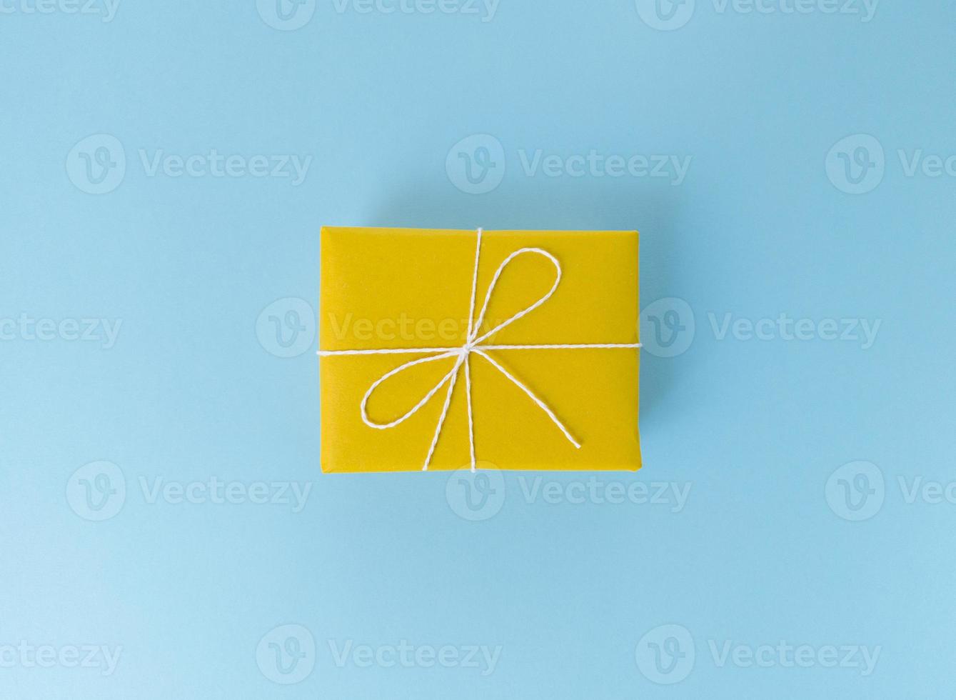 confezione regalo gialla su sfondo blu foto