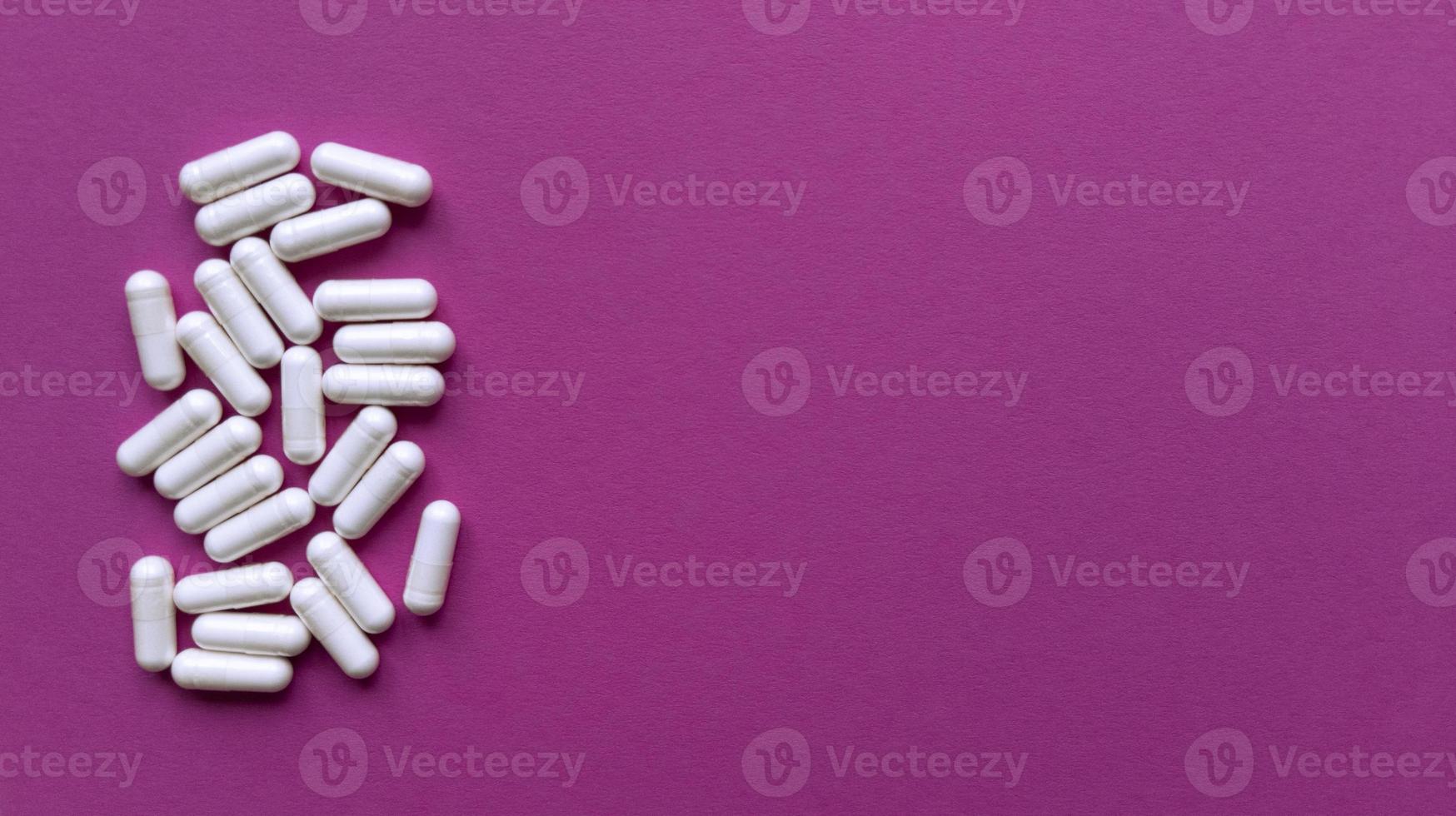 Pillole bianche su sfondo rosa semplice piatto laici con texture pastello e copia spazio concetto medico stock foto