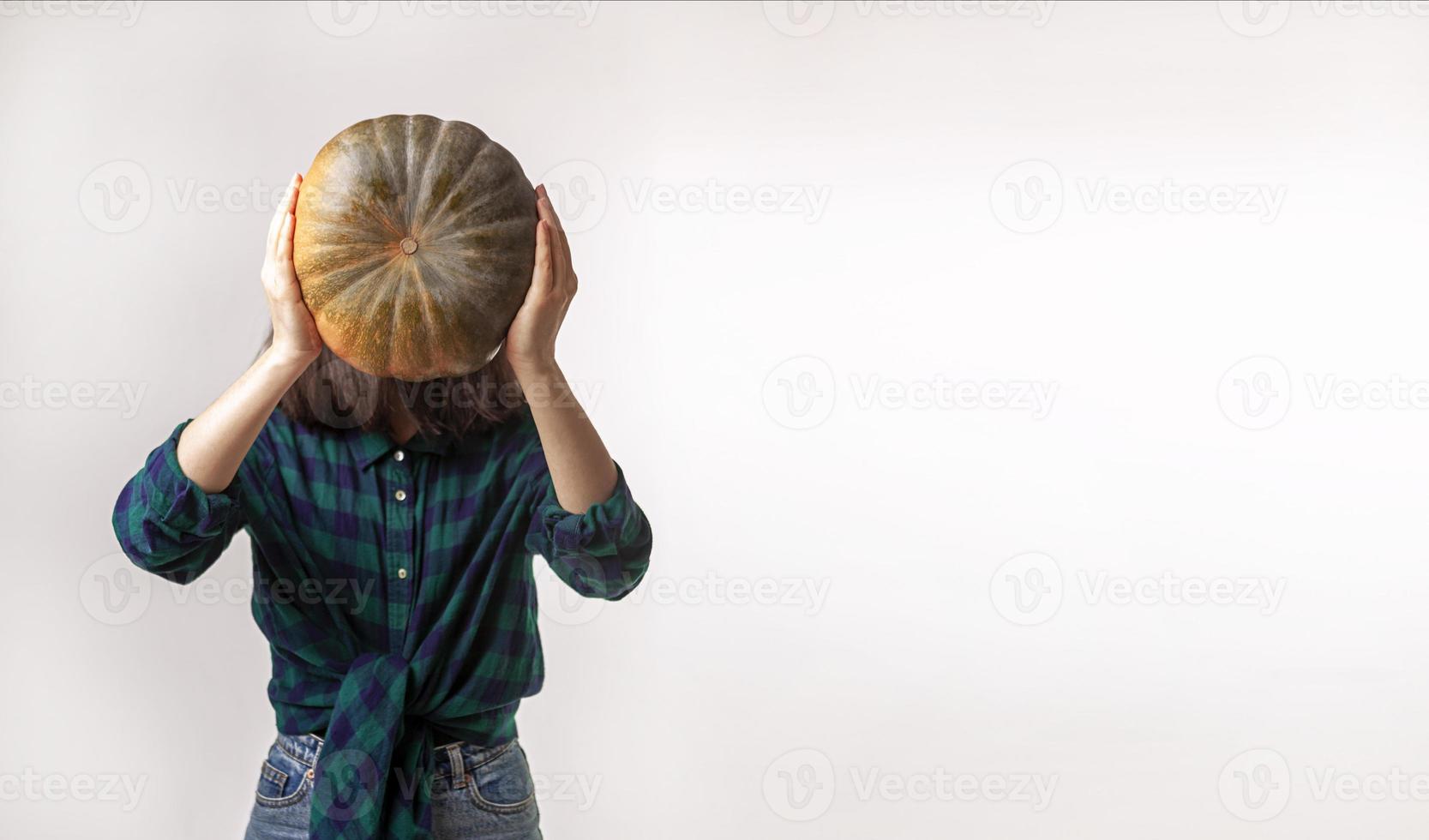 La donna senza volto sta tenendo la foto di concetto della zucca con lo spazio della copia