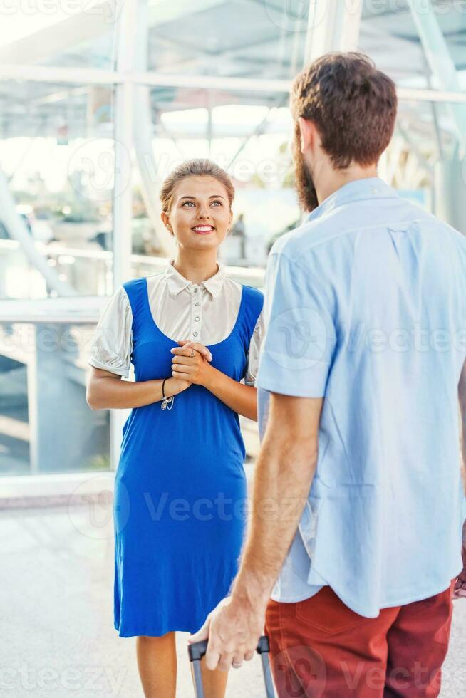 bellissimo giovane assistente di volo in aeroporto che spiega il modo foto