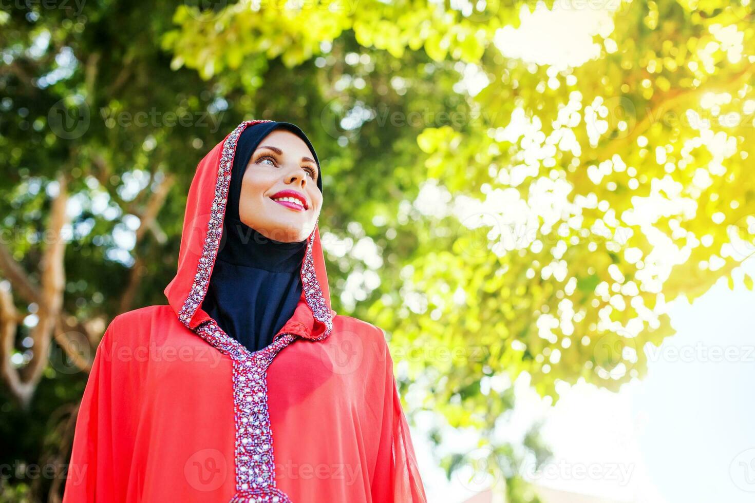 bellissimo musulmano caucasico donna indossare rosso vestito e hijab nel il parco foto