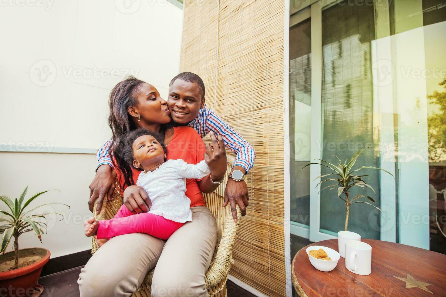 adorabile africano famiglia a balcone avendo tè foto