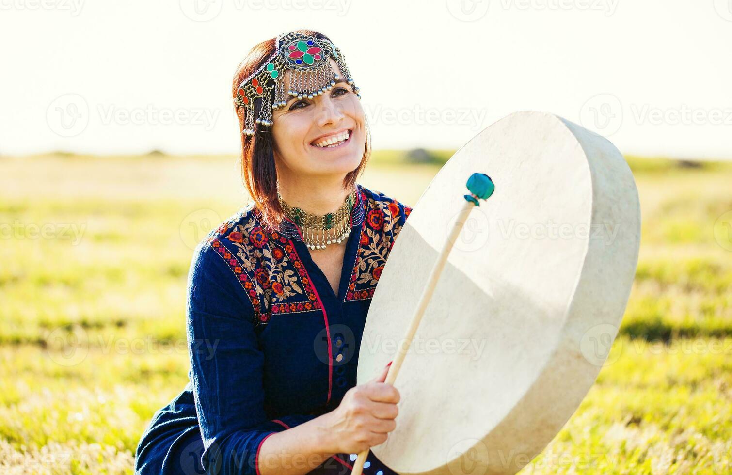 donna nel tradizionale etnico Abiti giocando tamburo foto
