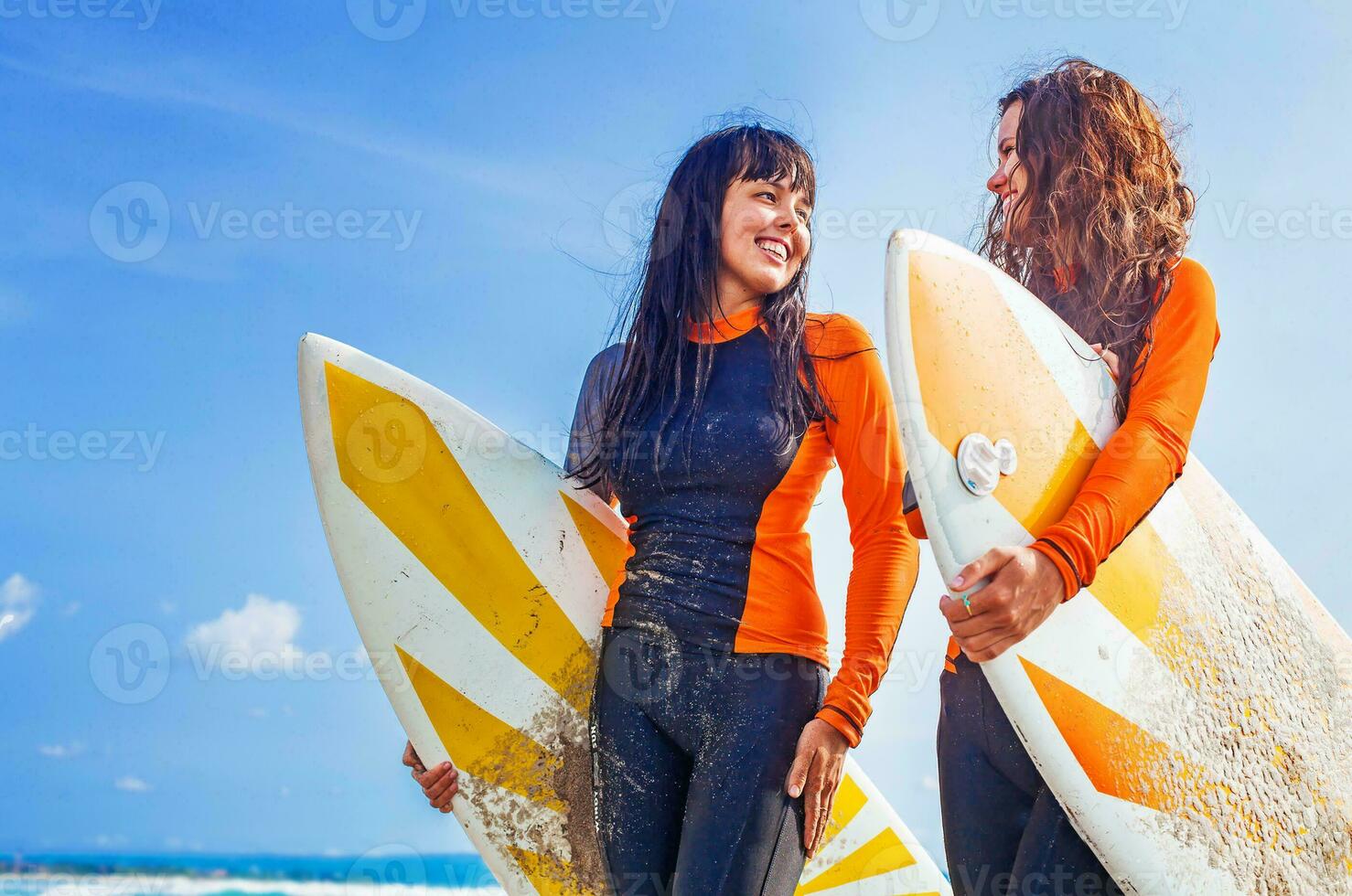 surfer ragazze discutere qualcosa e sorridente foto