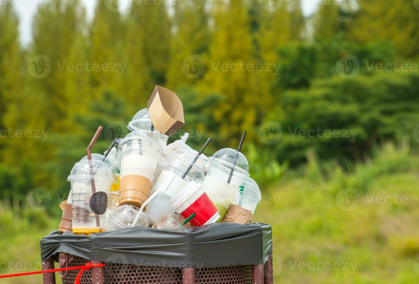 pieno di plastica tazza nel riciclare bidone nel il natura. foto