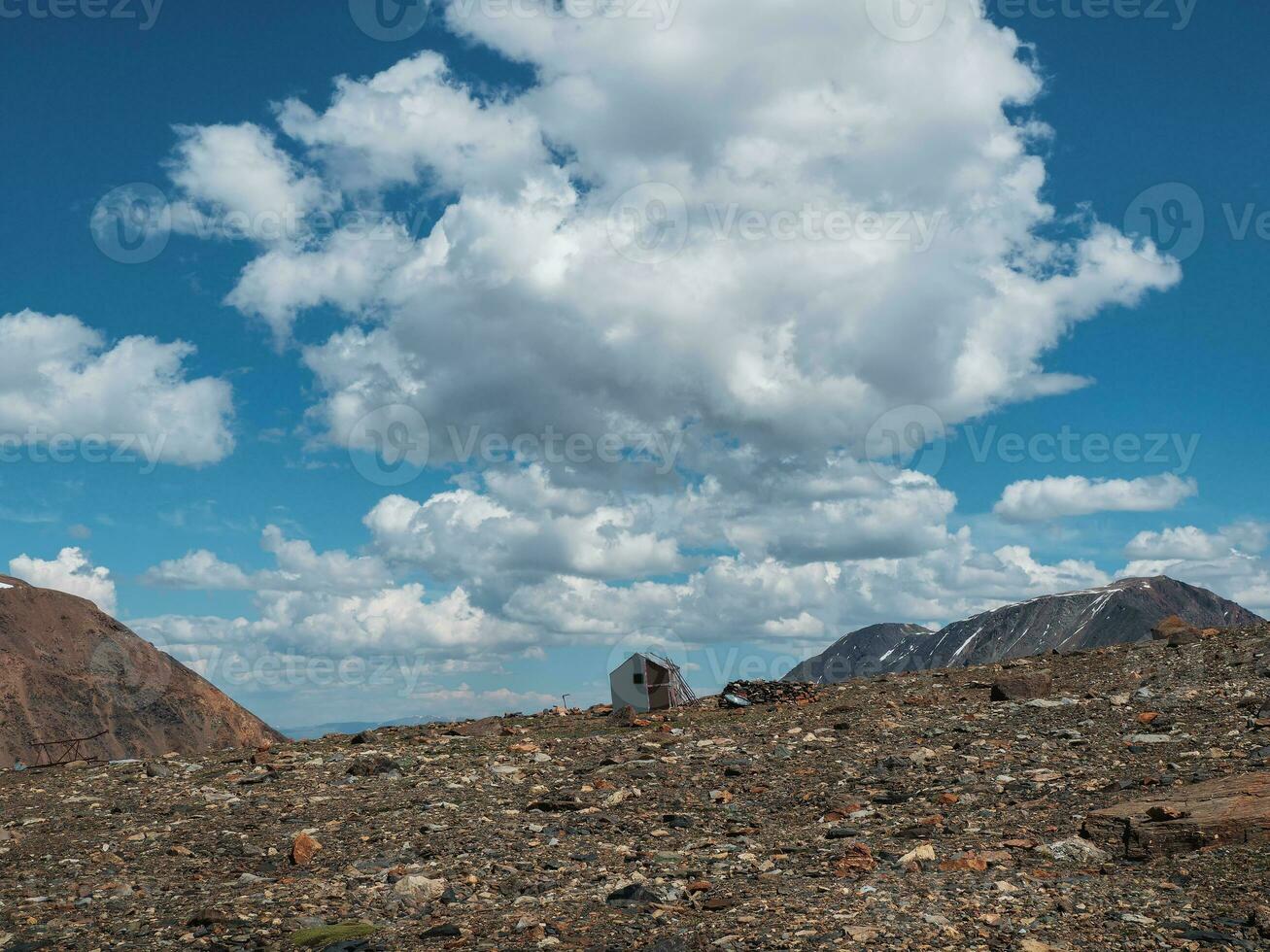 vecchio arrampicata Casa nel il montagne sotto un' blu nuvoloso cielo. vuoto alpinismo campo. autentico montagna soleggiato paesaggio nel il altai montagne. foto