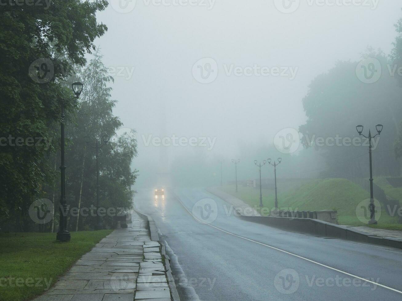 un' auto con suo luci su su un' nebbioso strada su un' freddo mattina foto