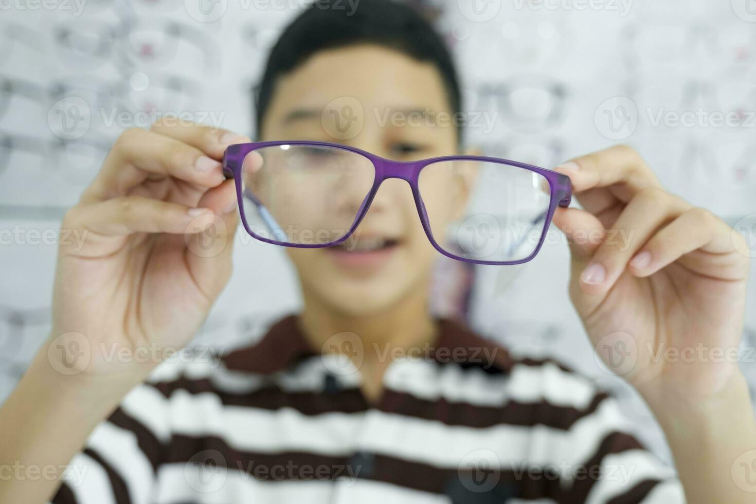 inteligente giovane ragazzo provando su nuovo occhiali. foto