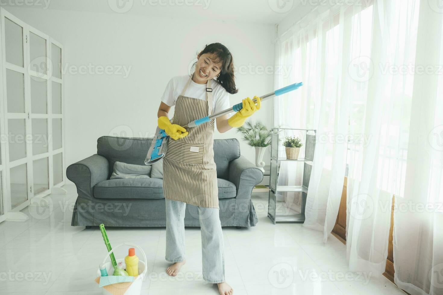 giovane donna avendo divertimento mentre pulizia a casa. foto
