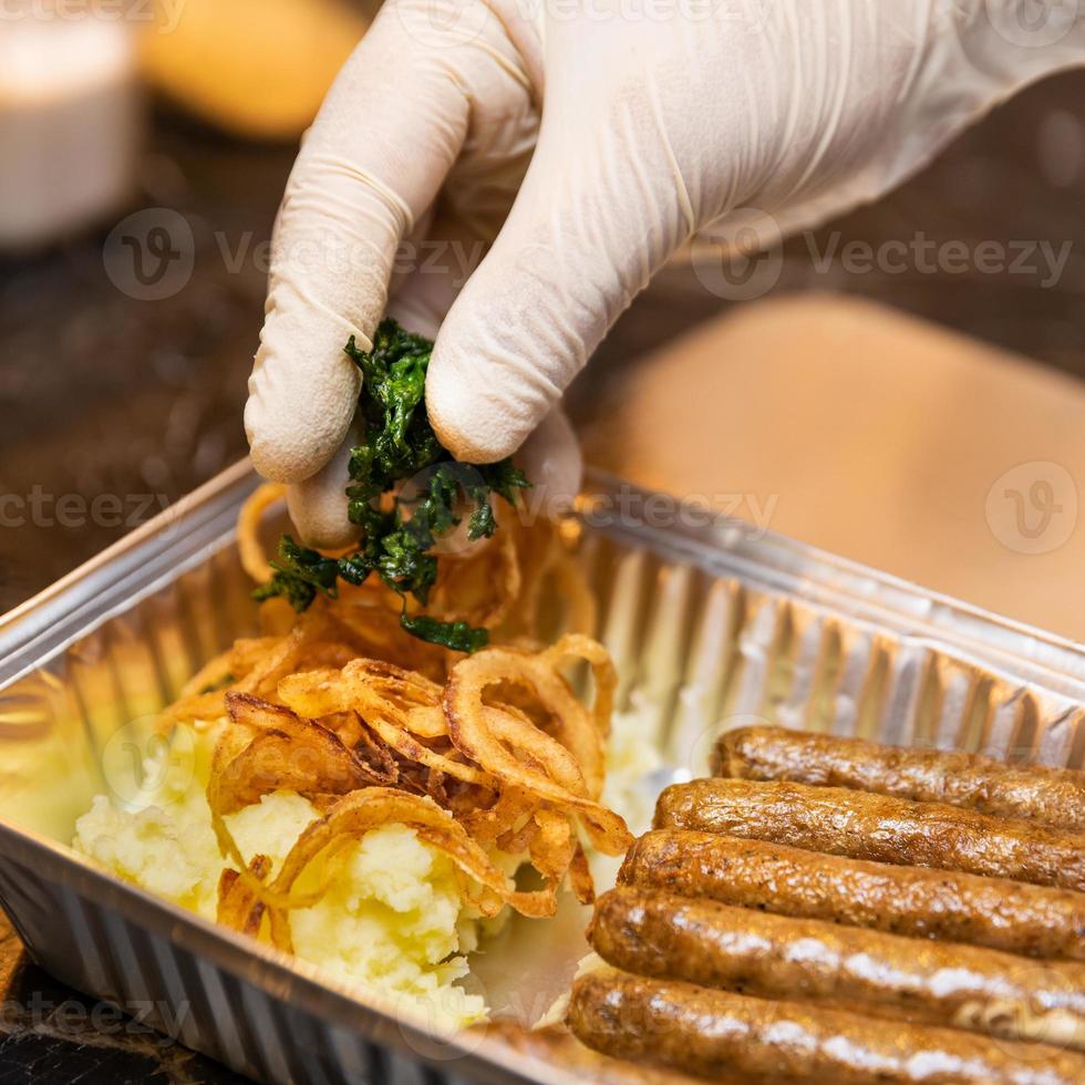 chef che mette i verdi sulle salsicce tedesche foto