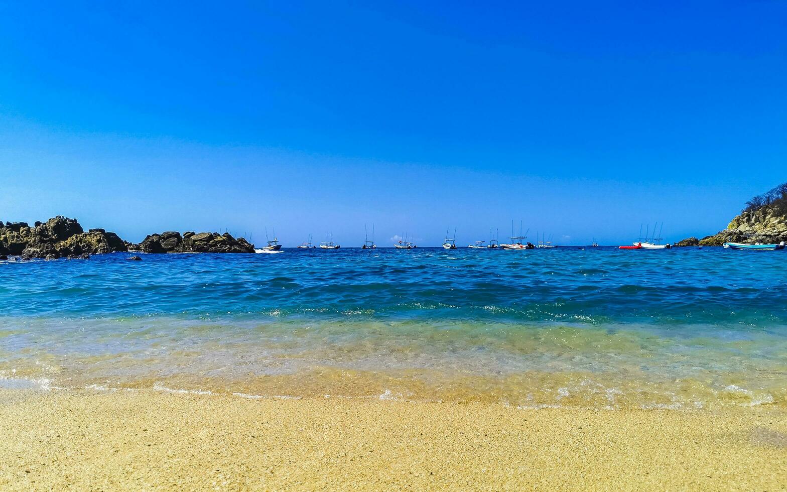 spiaggia sabbia blu turchese acqua onde rocce panorama puerto escondido. foto