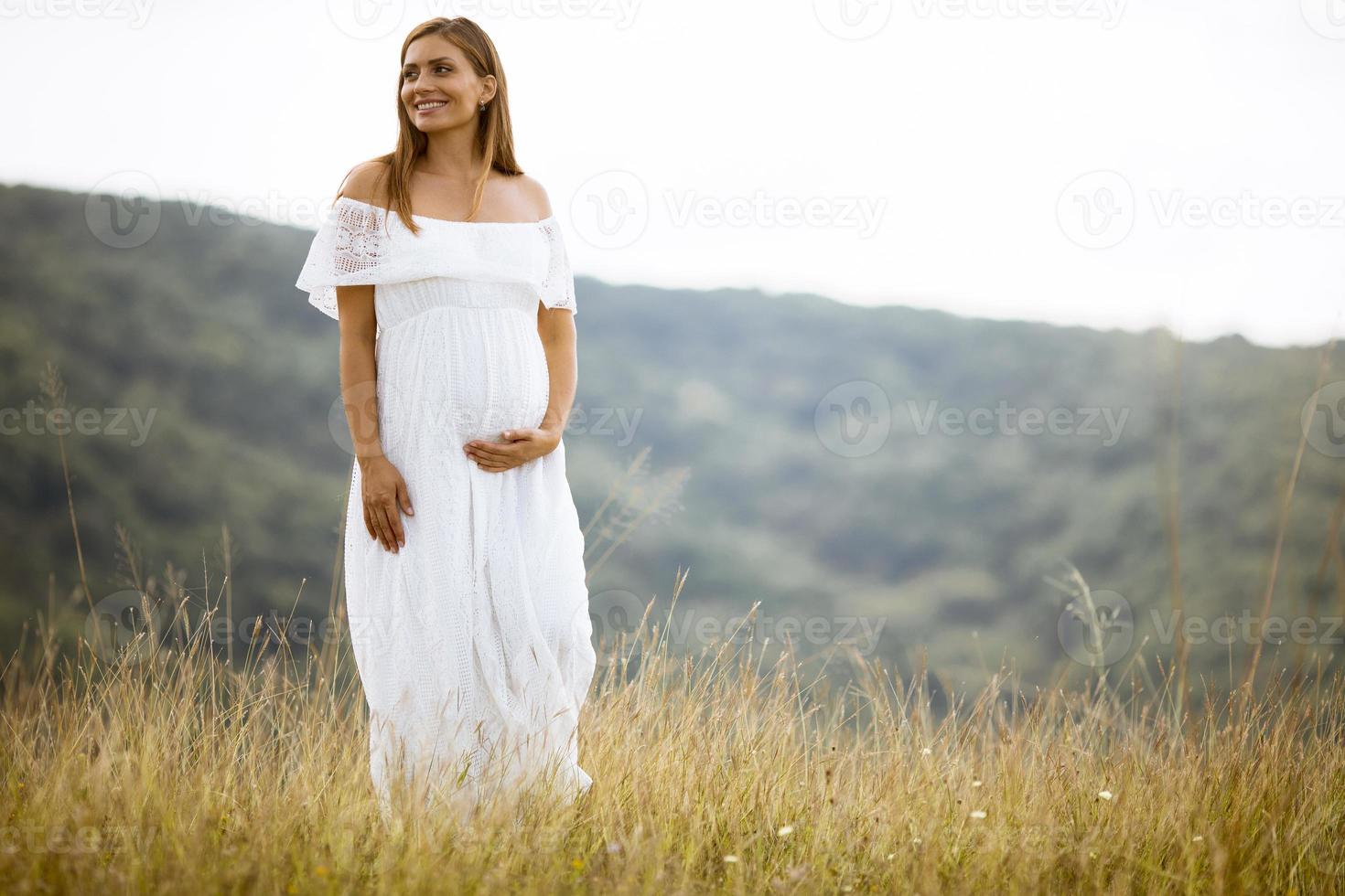 giovane donna incinta al campo foto