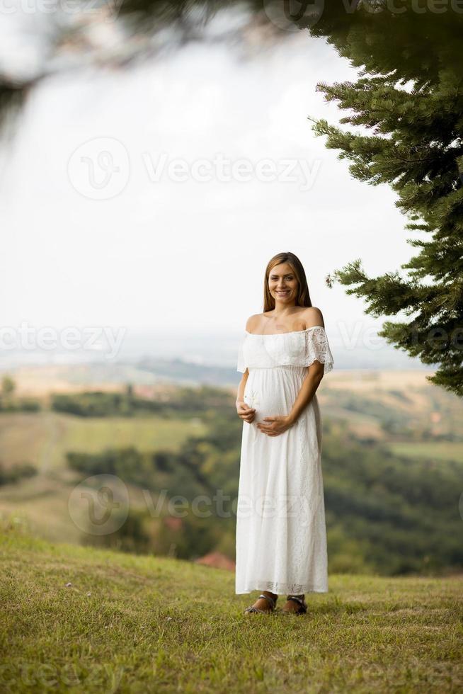 giovane donna incinta nella foresta foto