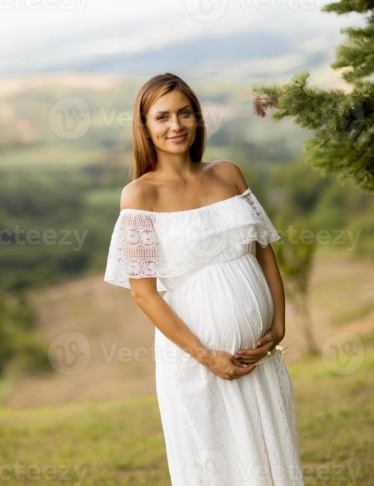 giovane donna incinta nella foresta foto