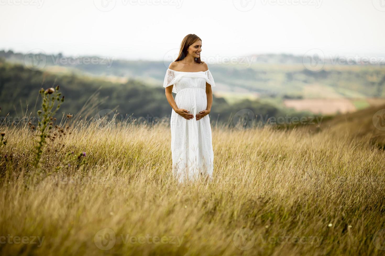 giovane donna incinta al campo foto