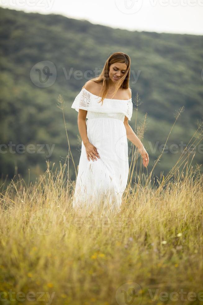 giovane donna incinta al campo foto