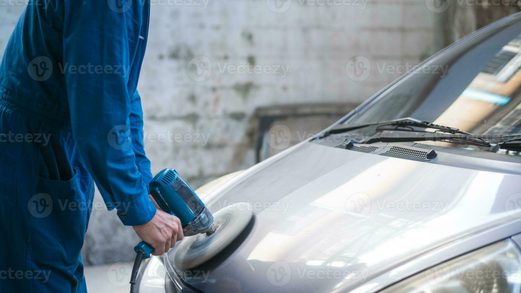 avvicinamento uomo mano è utilizzando auto lucidatura macchina nel riparazione meccanico pittura negozio foto