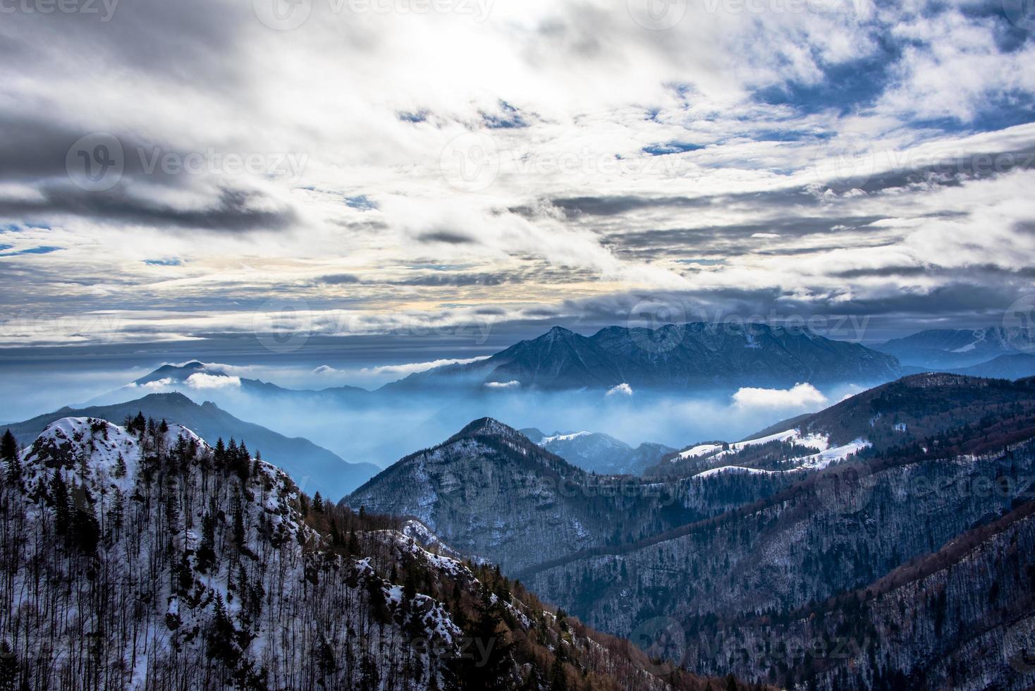 vette alpine innevate tra le nuvole due foto