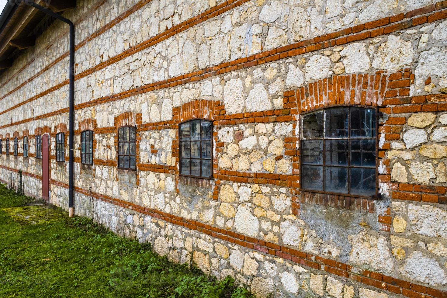 muro di pietra bianca con linea di mattoni rossi foto