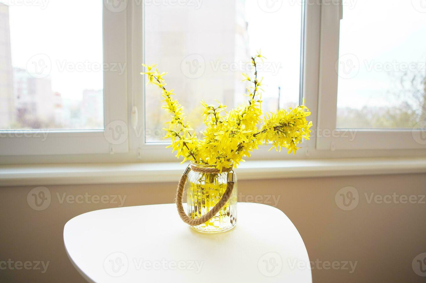 un' mazzo di giallo fiori nel un' vaso In piedi su un' bianca tavolo foto