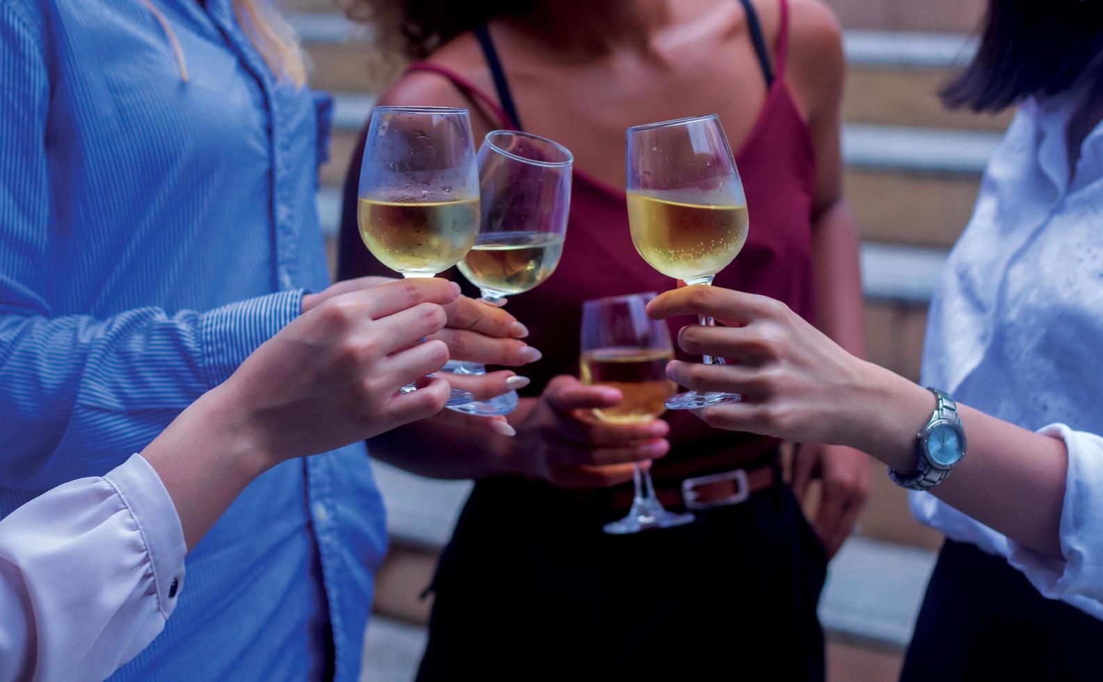 squadra di affari che è felice di celebrare la vittoria nei bicchieri di alcol dell'ufficio insieme a vino e champagne foto