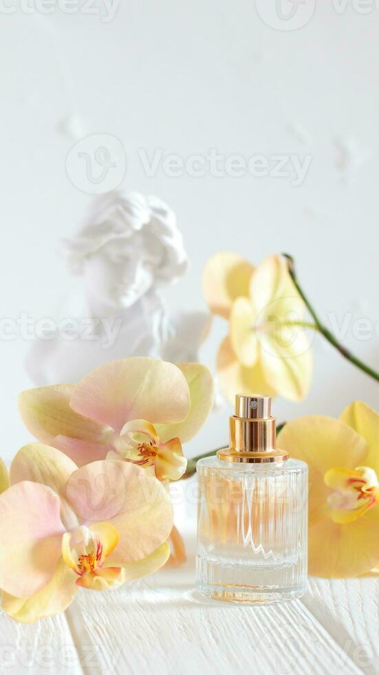 profumo bicchiere bottiglia con orchidea fiori e testa scultura testa foto