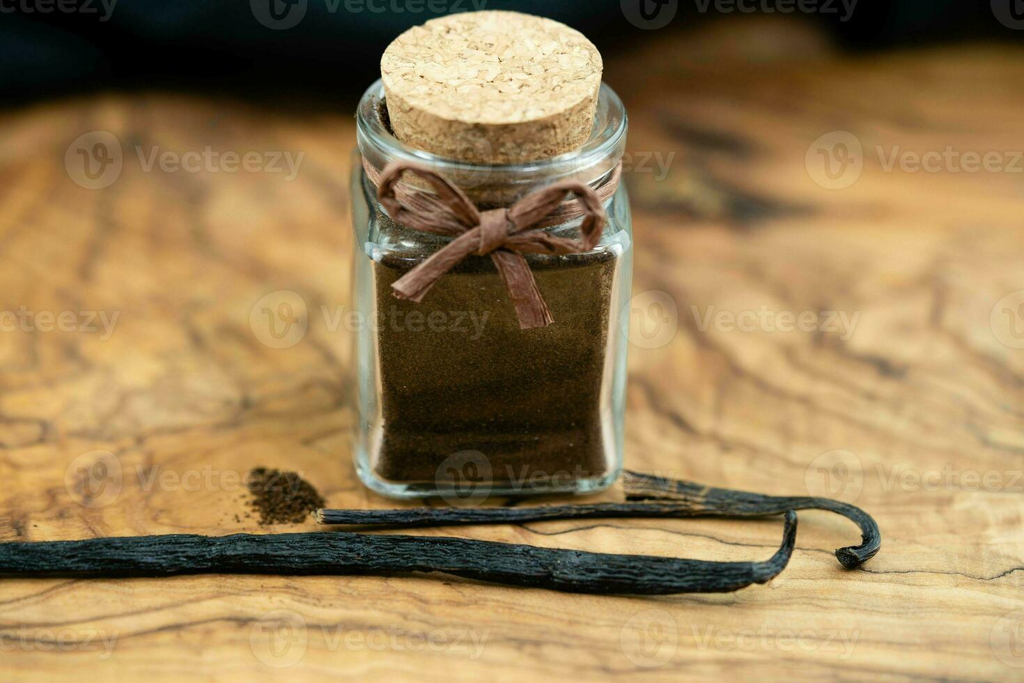 vaniglia bastoni e polvere su oliva legna foto
