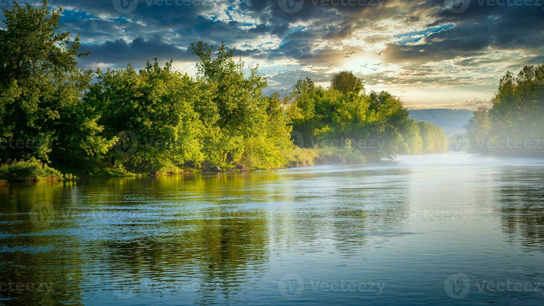 fiume con alberi a tramonto foto