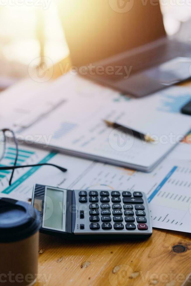 primo piano del contabile che lavora e analizza i rapporti finanziari contabilità del progetto con grafico grafico e calcolatrice in ufficio moderno finanza e concetto di business. foto