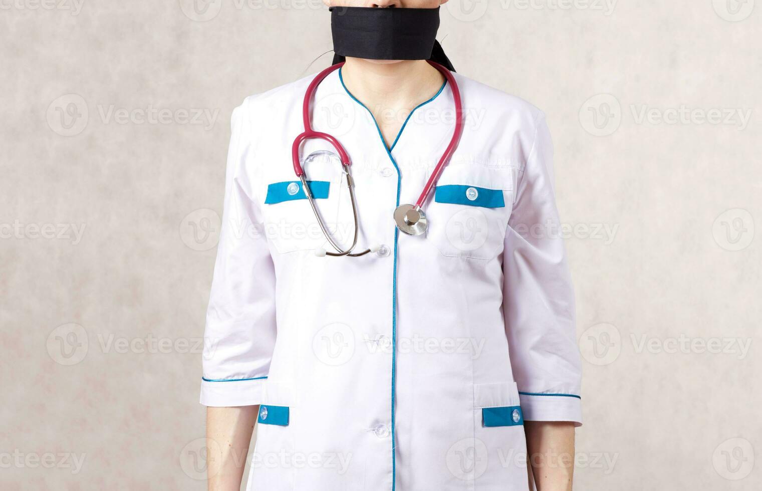 un' giovane donna vestito nel un' medico uniforme con un' chiuso bocca foto