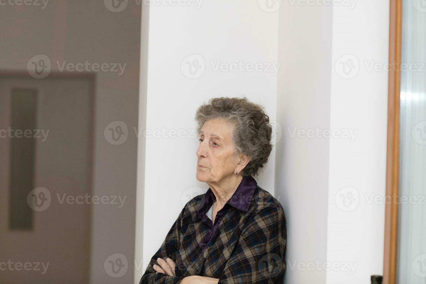 vecchio donna di 80 anni vecchio soggiorni vicino per il finestra foto