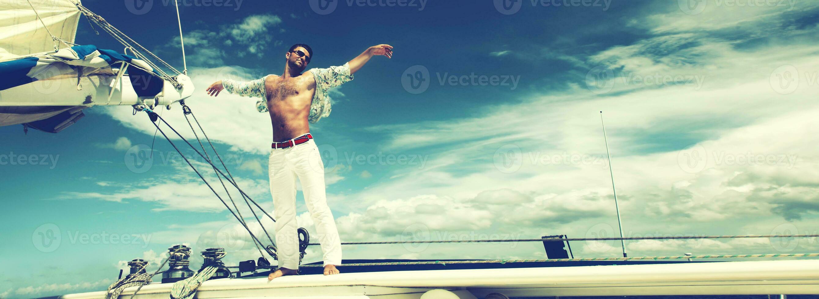 giovane uomo che naviga la sua barca in mare aperto foto