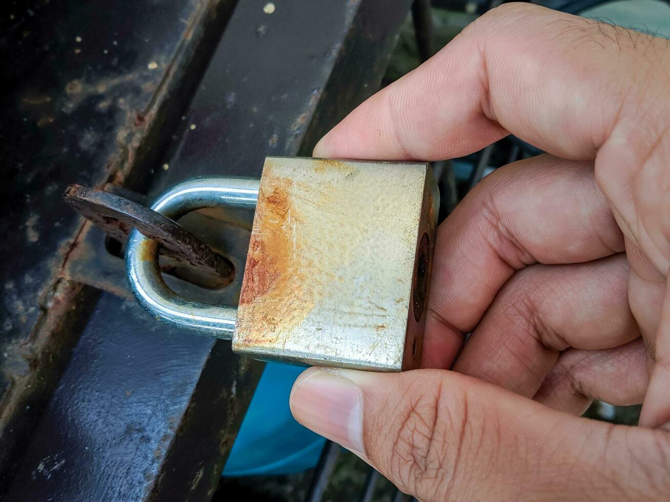 un' dell'uomo mano Tenere un vecchio, arrugginito lucchetto foto