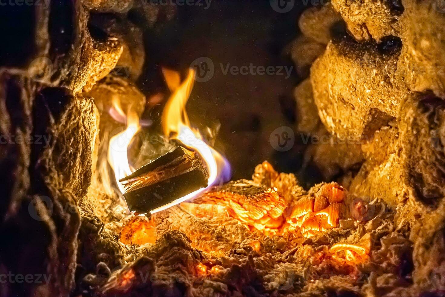 bellissimo camino antico con fuoco a fiamma leggera per il riscaldamento della stanza dell'edificio foto