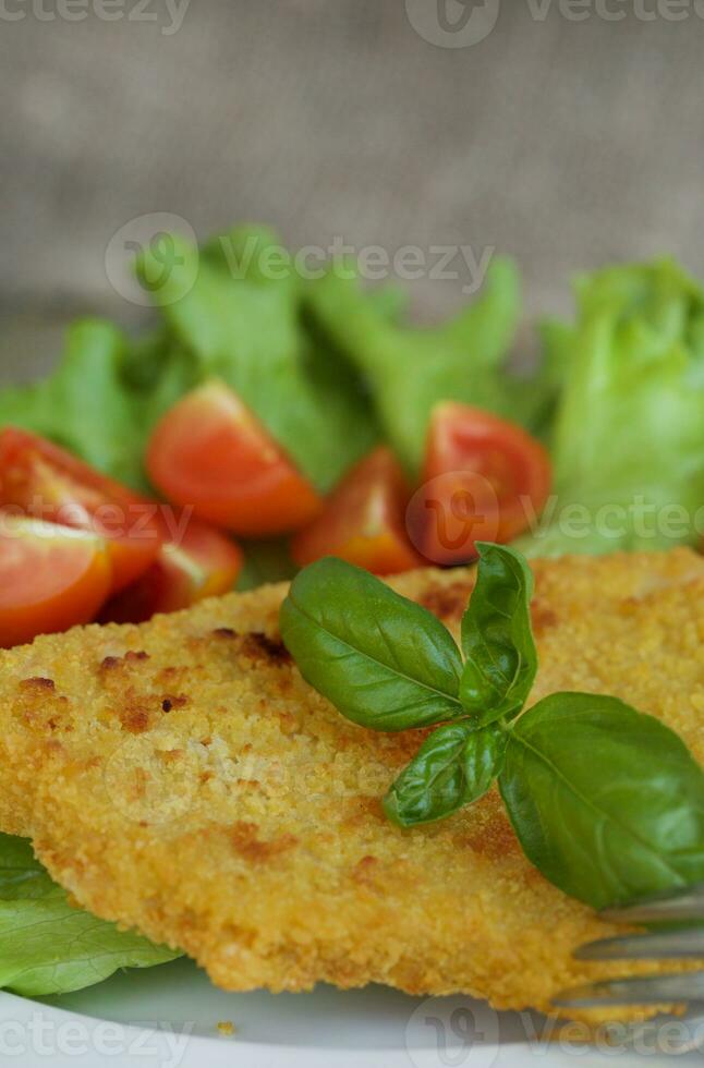 pollo cotoletta con ciliegia pomodori e verde insalata le foglie. foto