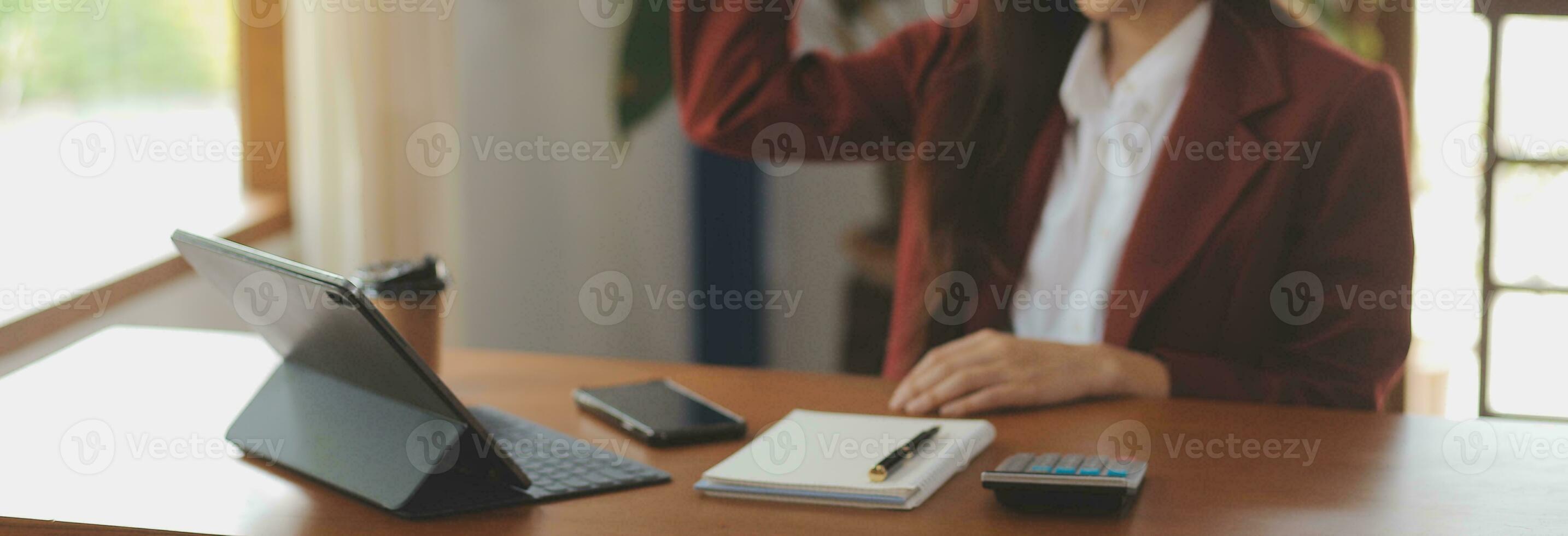 tiro di un' asiatico giovane attività commerciale femmina Lavorando su il computer portatile nel sua postazione di lavoro. foto