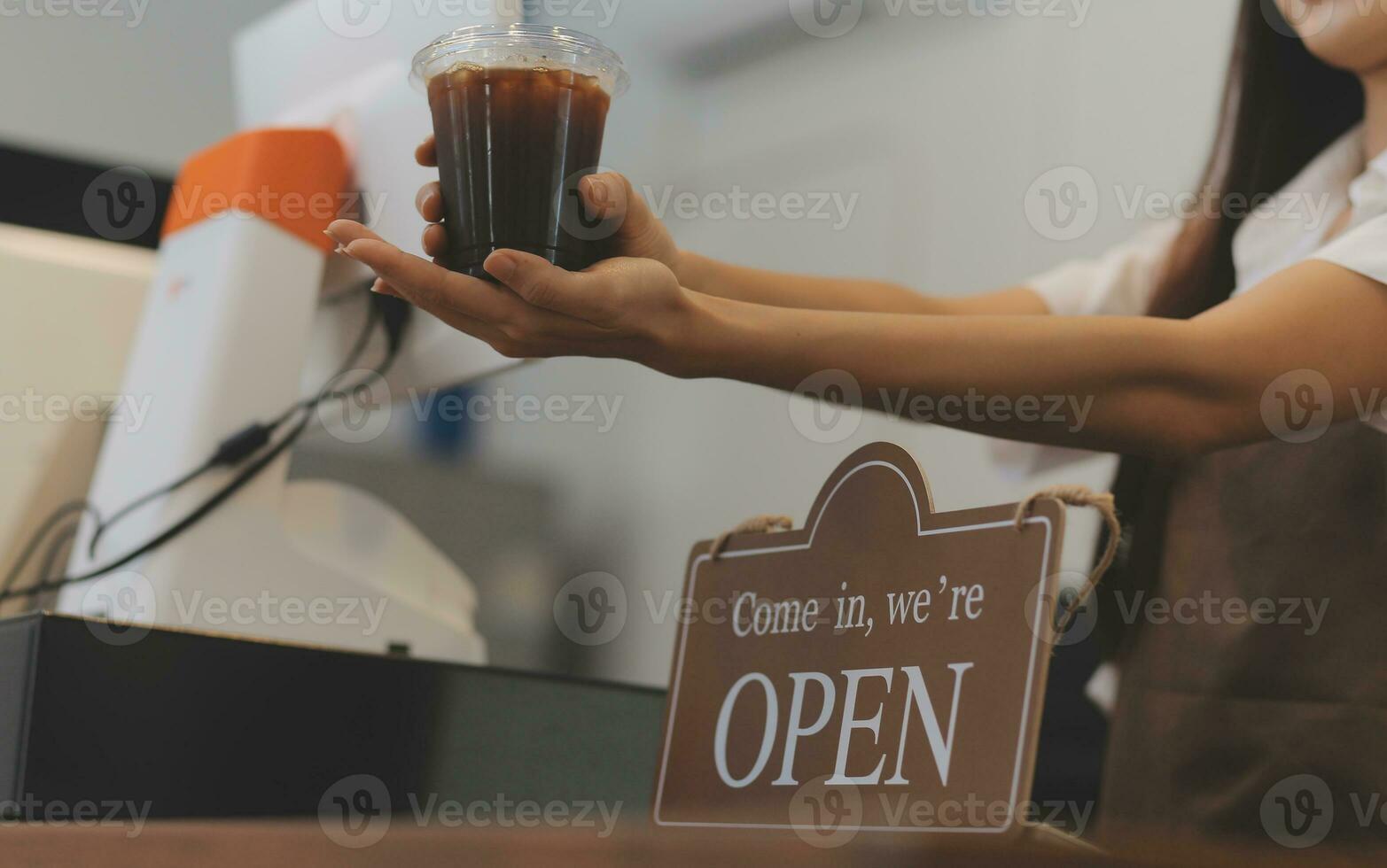 benvenuto. aprire. barista, cameriera donna svolta Aperto cartello tavola su bicchiere porta nel moderno bar caffè negozio pronto per servizio, bar ristorante, Al dettaglio negozio, piccolo attività commerciale proprietario, cibo e bevanda concetto foto