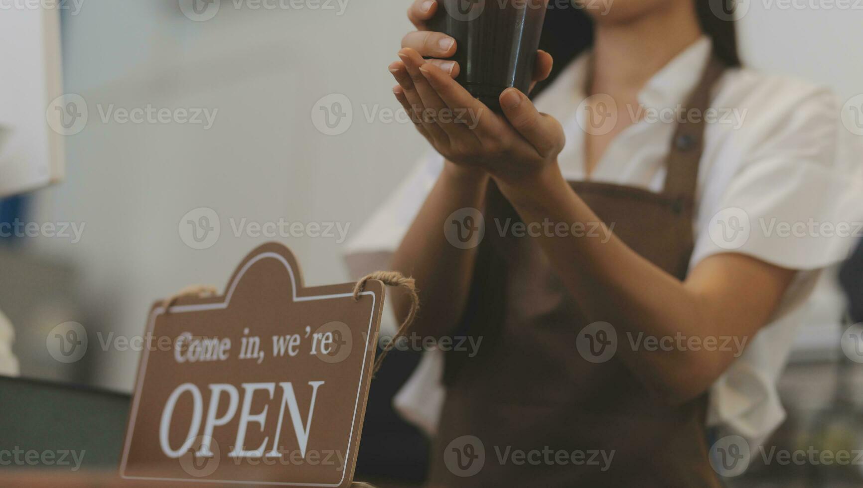 giovane imprenditore Tenere Aperto cartello su bicchiere porta a bar foto