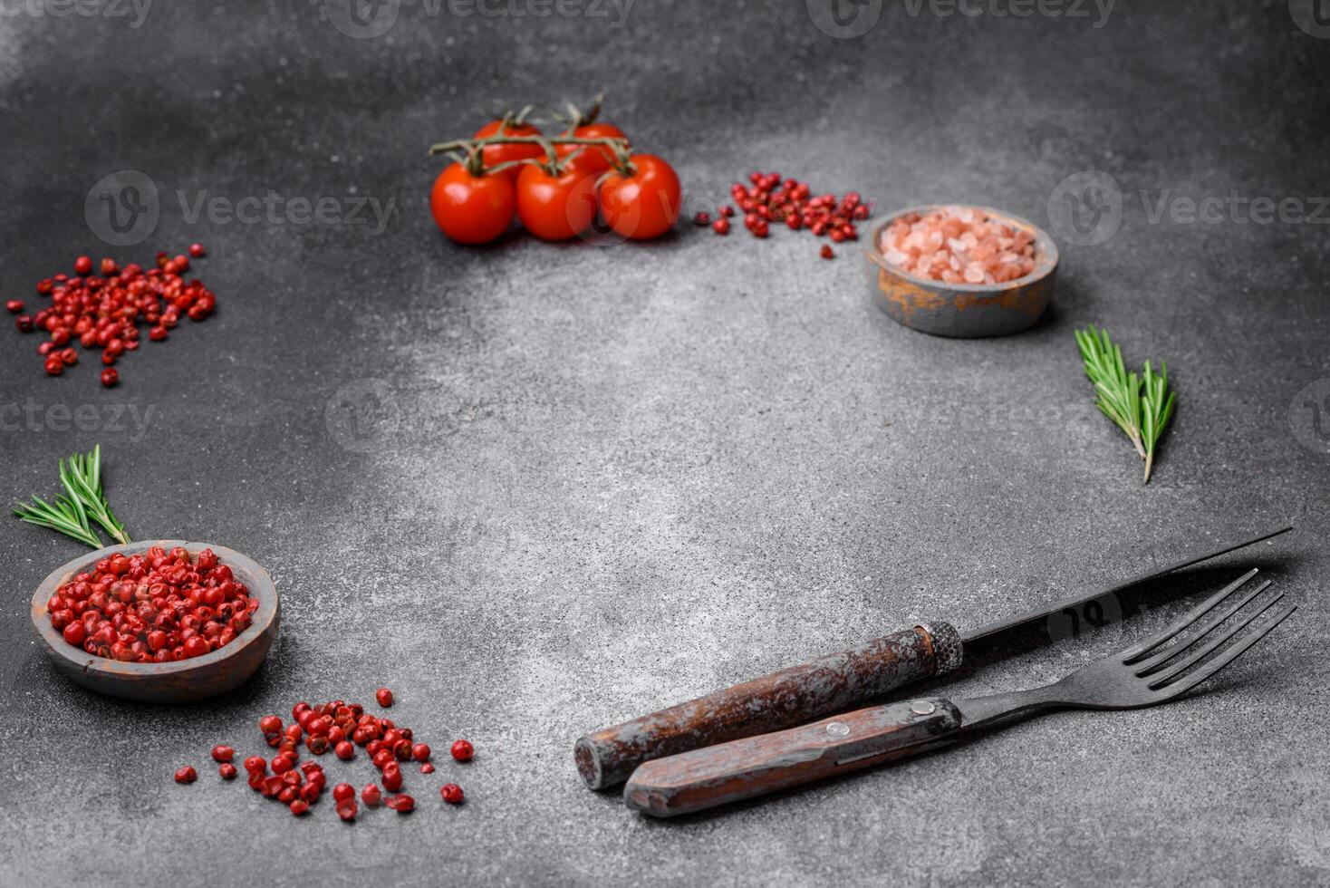 ingredienti, spezie, sale, pomodori, rosmarino e posate coltello e forchetta foto