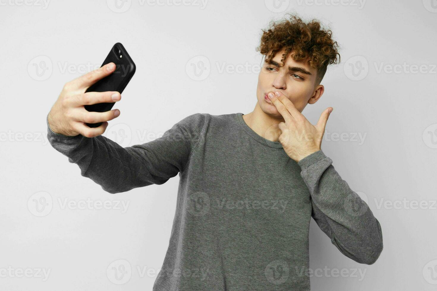 bello giovane uomo tecnologia con Telefono autoscatto isolato sfondo foto