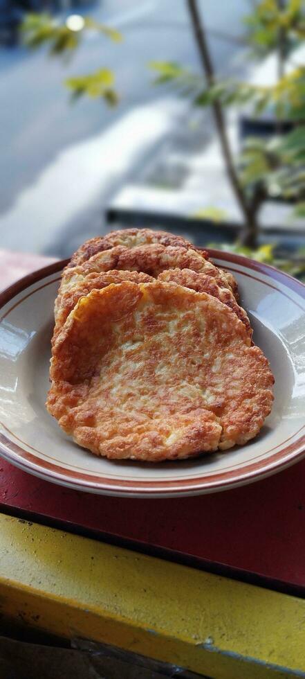 croccante fritte Pancakes su un' piatto nel il mattina. cibo fatto a partire dal un' miscela di uova, Riso, primavera cipolle fritte nel caldo olio. esso sembra piace un fritto con extra riso foto