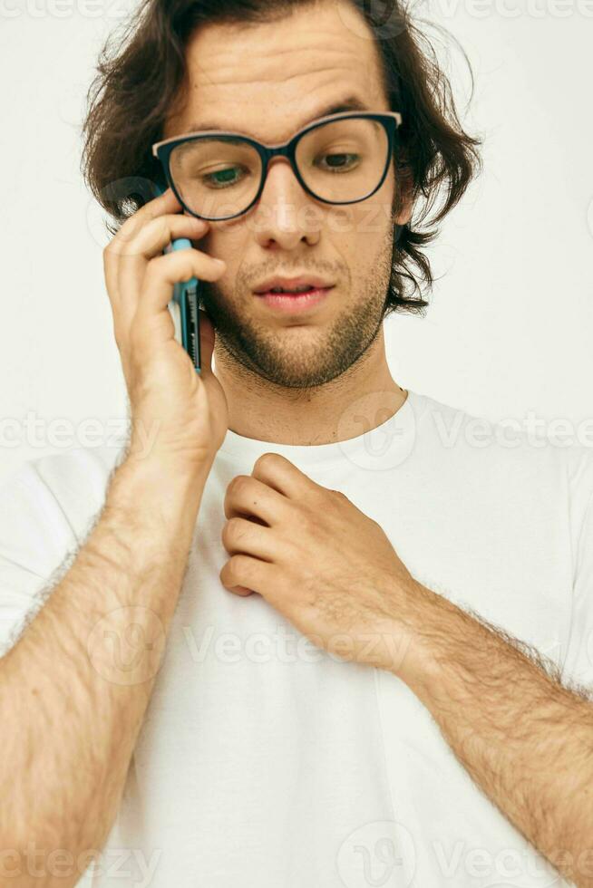 uomo nel un' bianca maglietta comunicazione di Telefono stile di vita inalterato foto